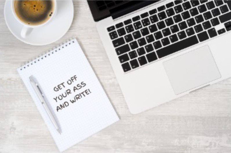 Laptop on Desk with a notepad next to it